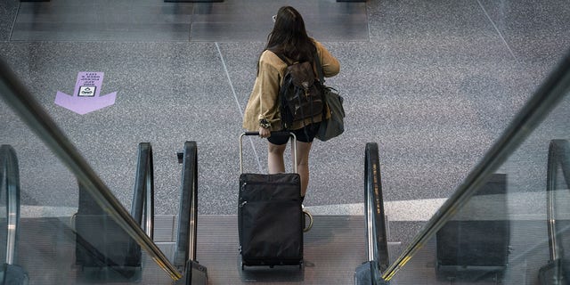 This file image shows a female traveler at Logan International Airport in Boston, Massachusetts, on Thursday, April 21, 2022. 
